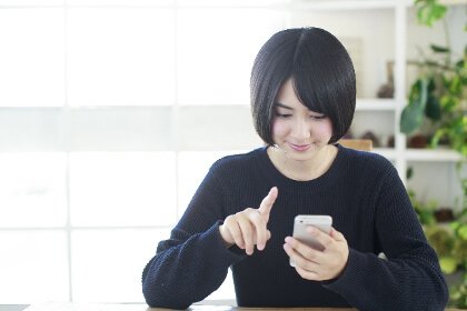 スマホをする女性の写真