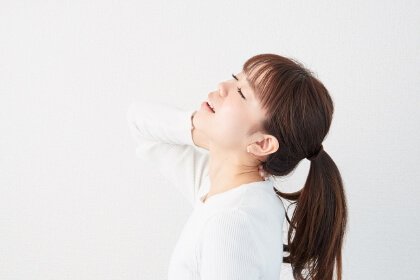 首がツラくて押さえている女性