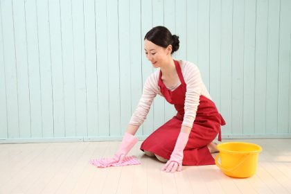 膝を着いて床掃除をする女性
